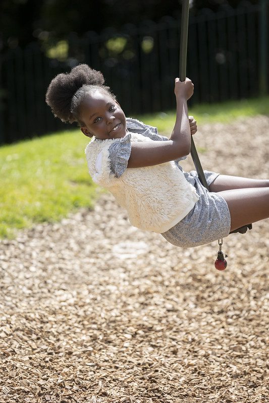 A girl plays on the rope swing.