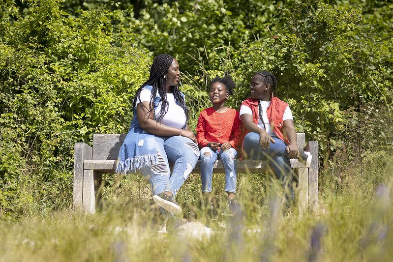 Mum and two young girls take a break on a bench at Ranscombe Farm.