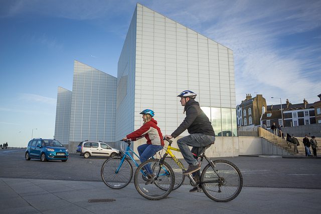 Cycling past modern building
