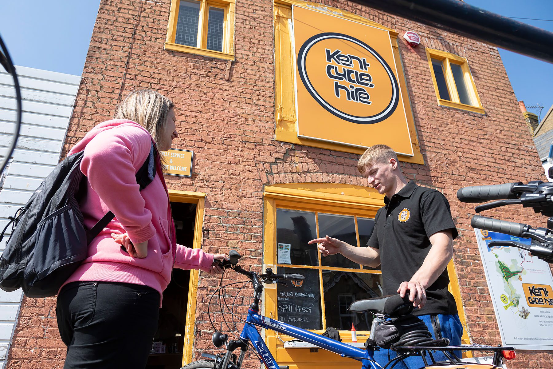 cycle hire employee showing women bike to hire