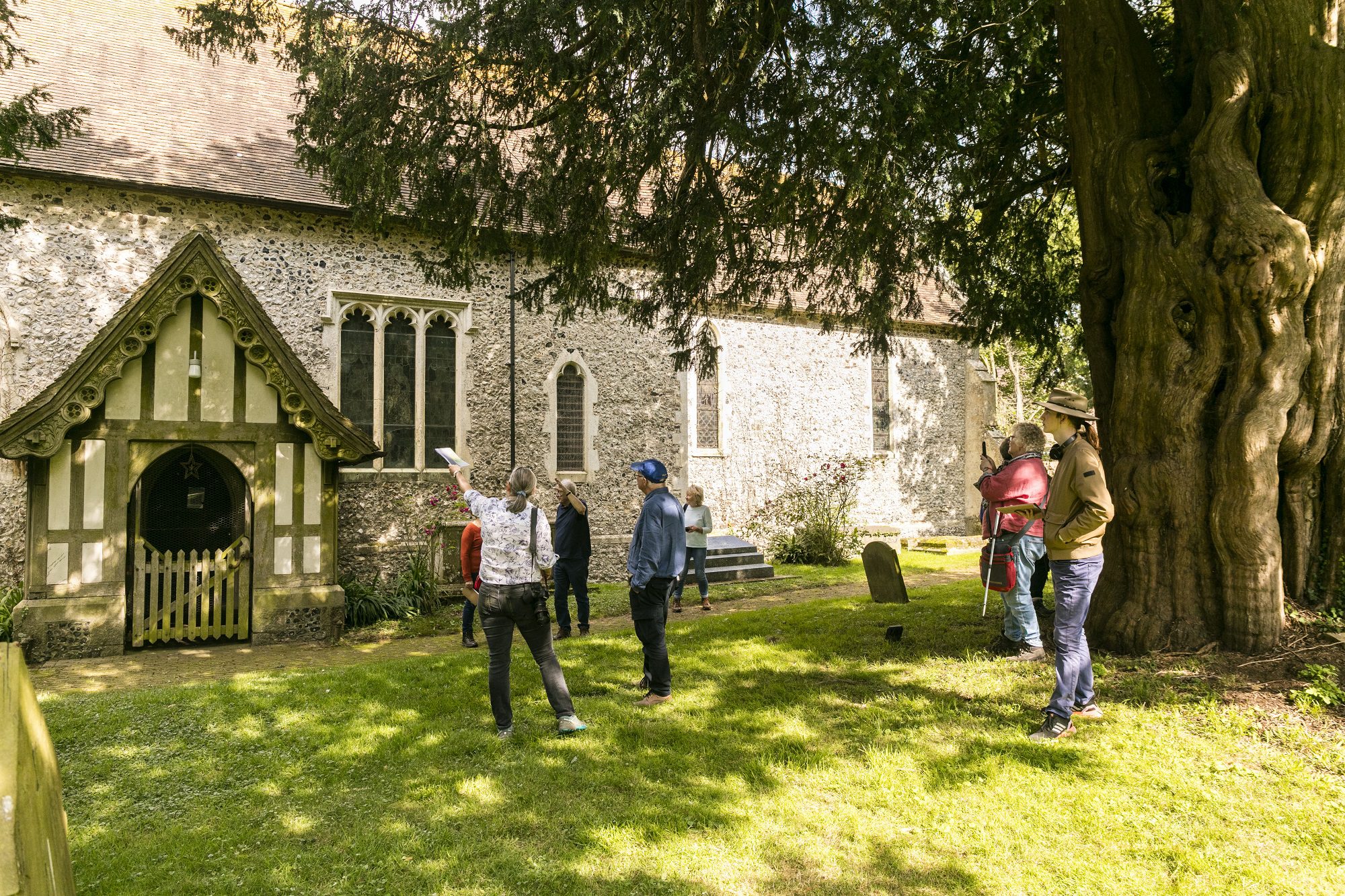 A group stand outside a church on a sunny day
