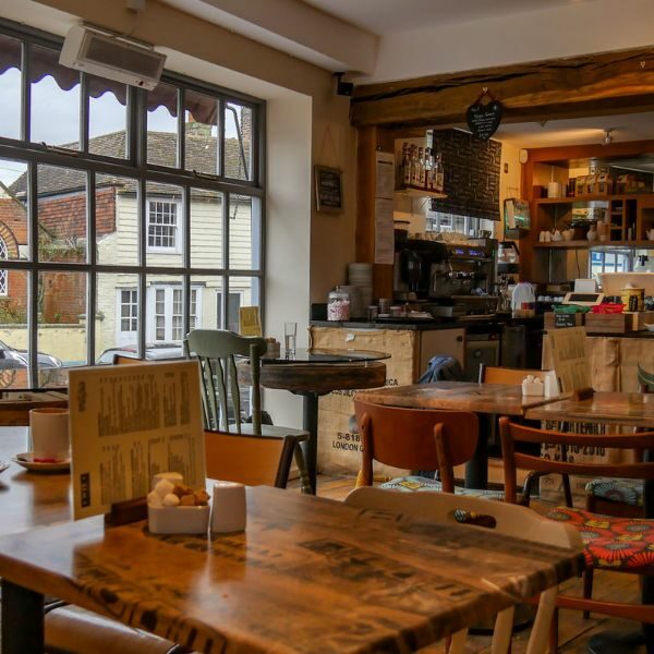 Inside of Wye Coffee and Kitchen. Rustic wooden tables and chair, with chalkboard menu on wall.