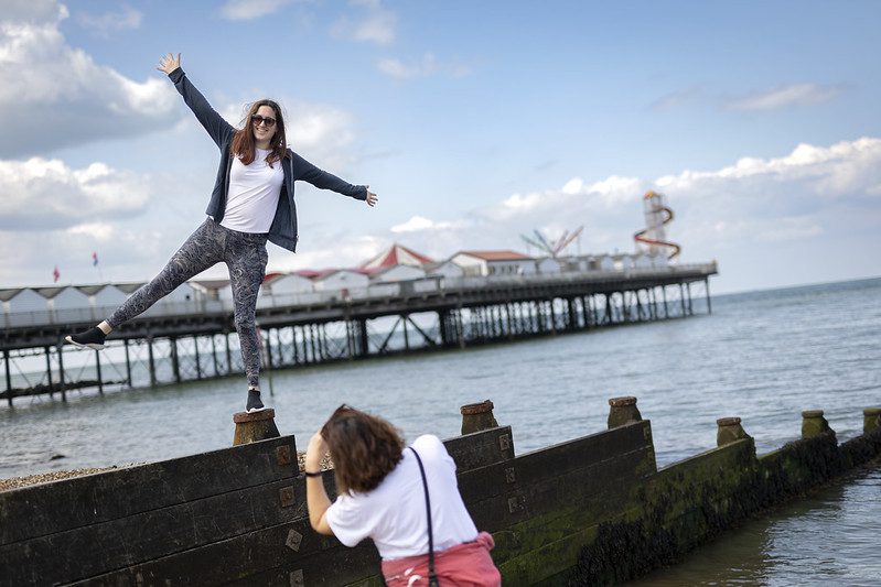 A women posing for pictures in front of Herne Bay Pier