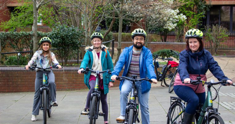 Four people sitting on electric bikes