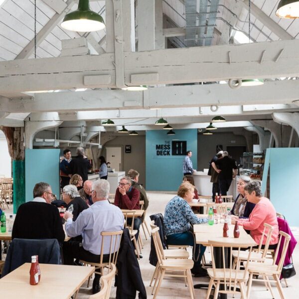 Visitors sats at tables enjoying lunch at the Mess Deck, The historic dockyard, Chatham