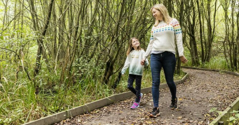 A woman and child walk down an accessible path holding hands.