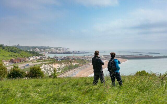 2 people looking out to sea on a cliff top