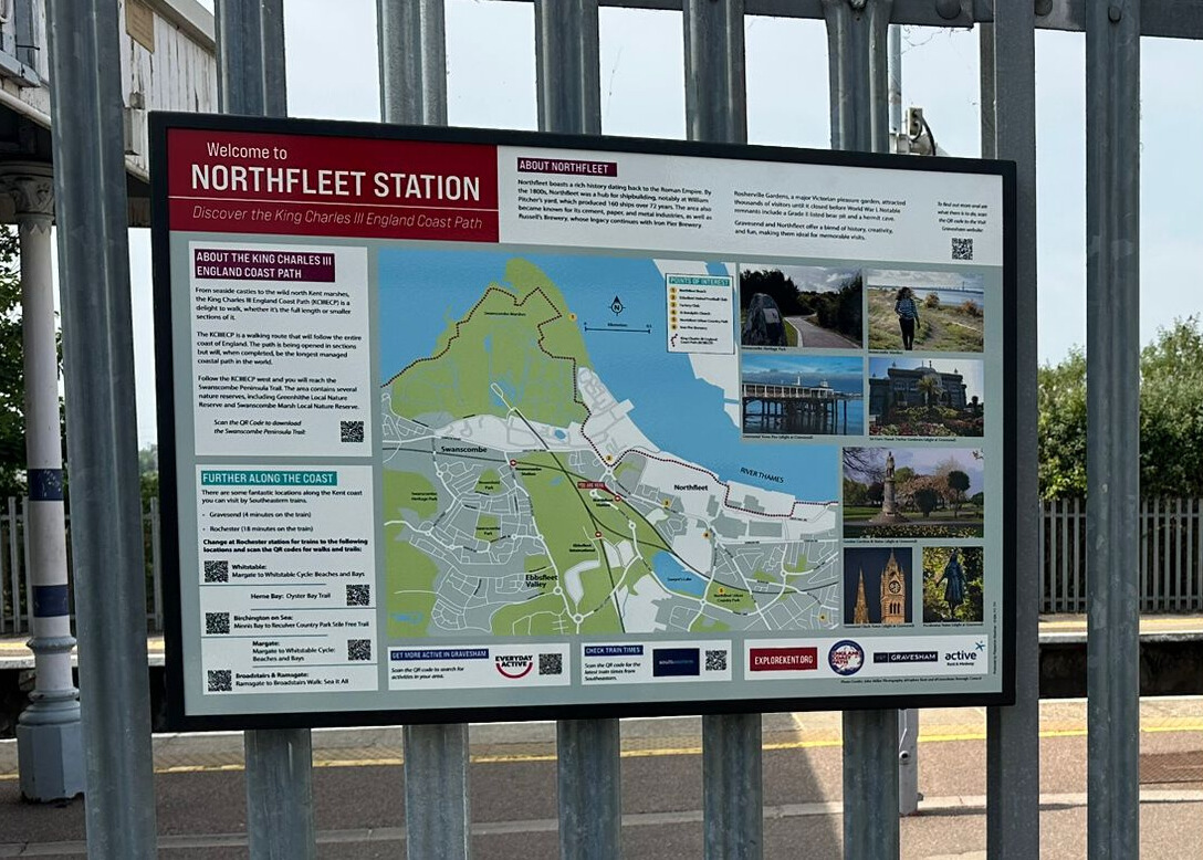 Railings at a station platform displaying a map of Northfleet.