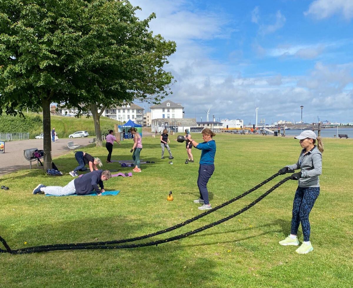 People using various pieces of outdoor gym equipment