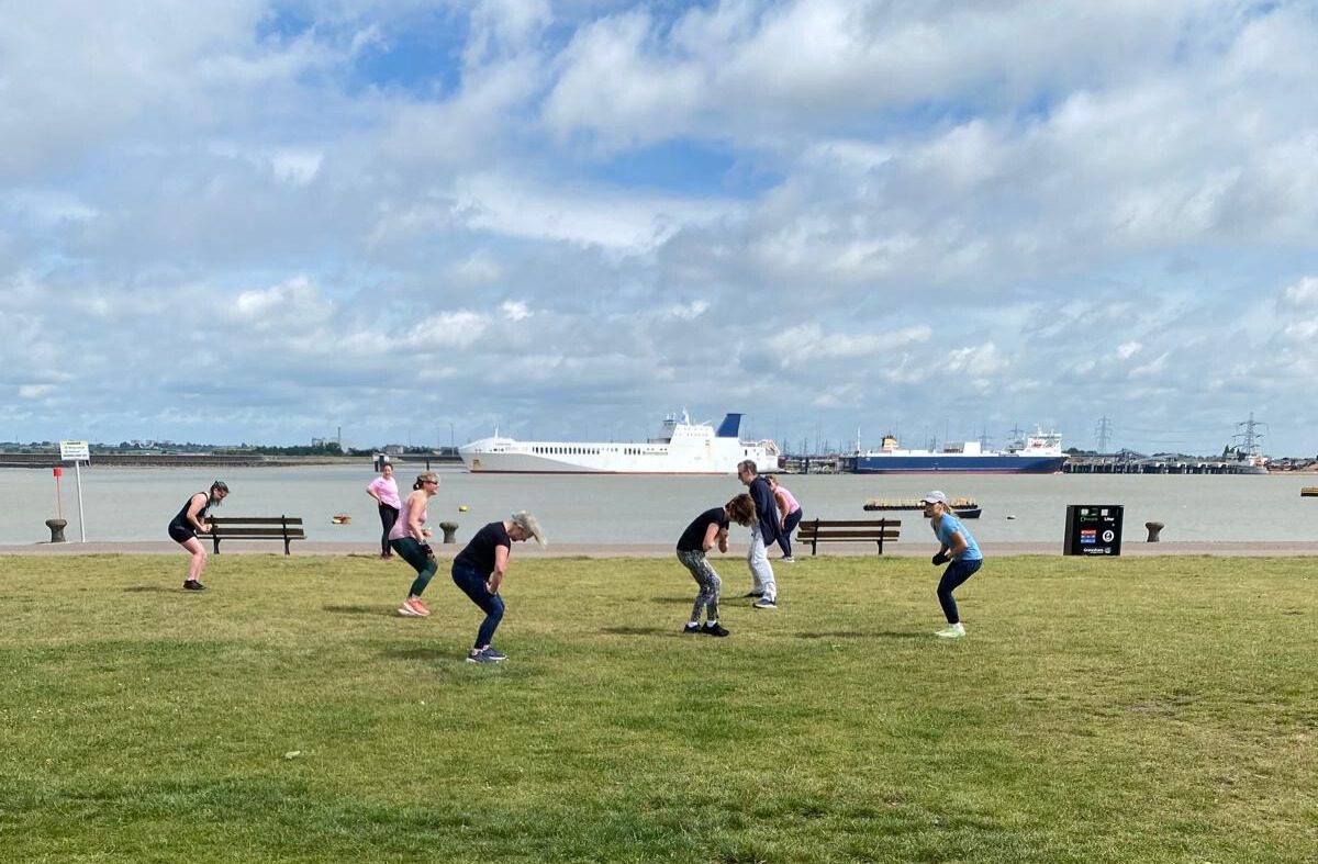 group of people doing outdoor exercise by the river