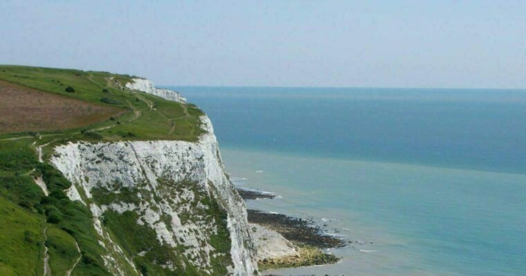 White Cliffs of Dover with grass at the top and the blue sea in the distance