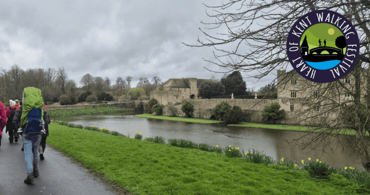 People walking past Leeds Castle with the Heart of Kent Walking Festival logo