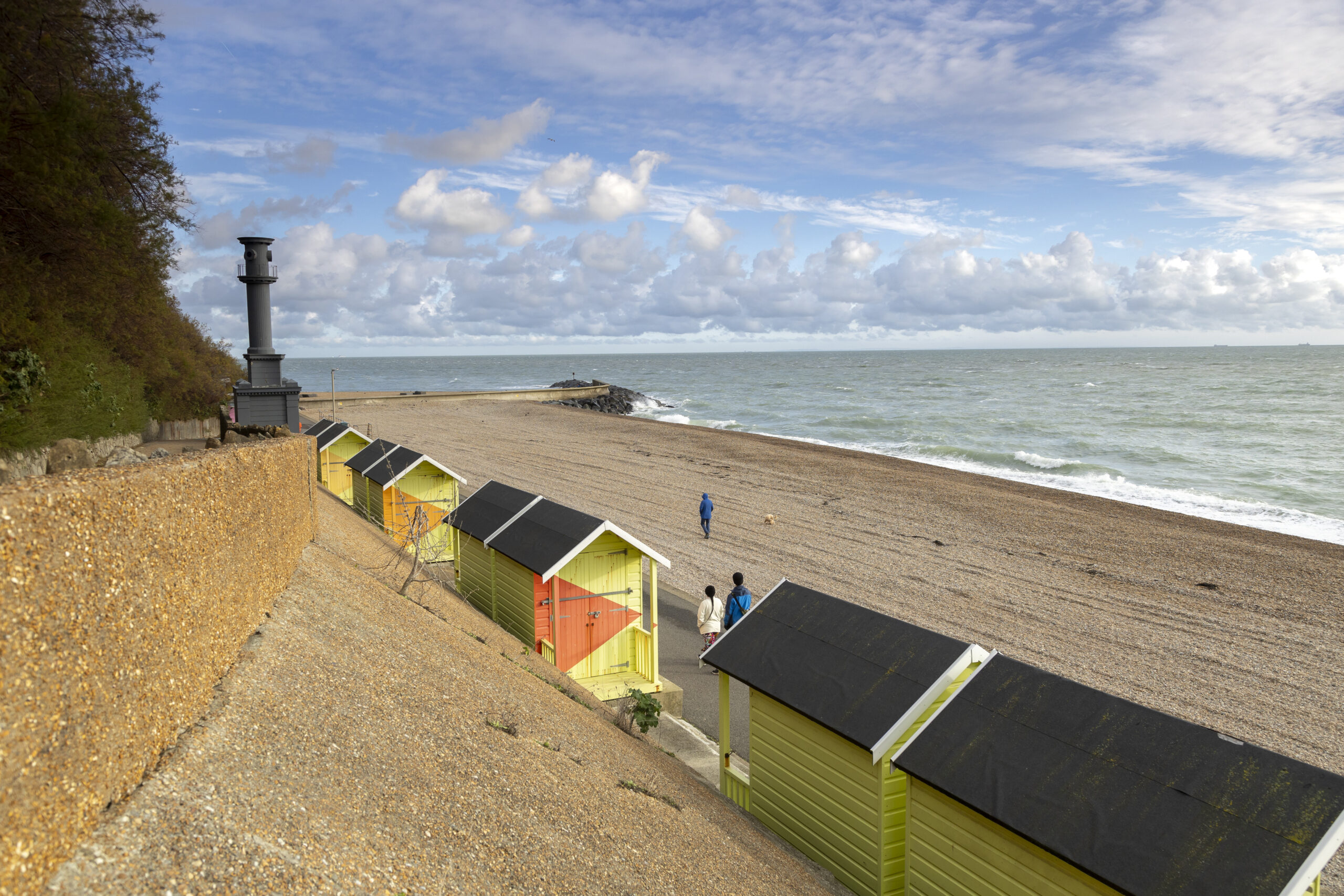 the sea on the right and some colourful beach huts