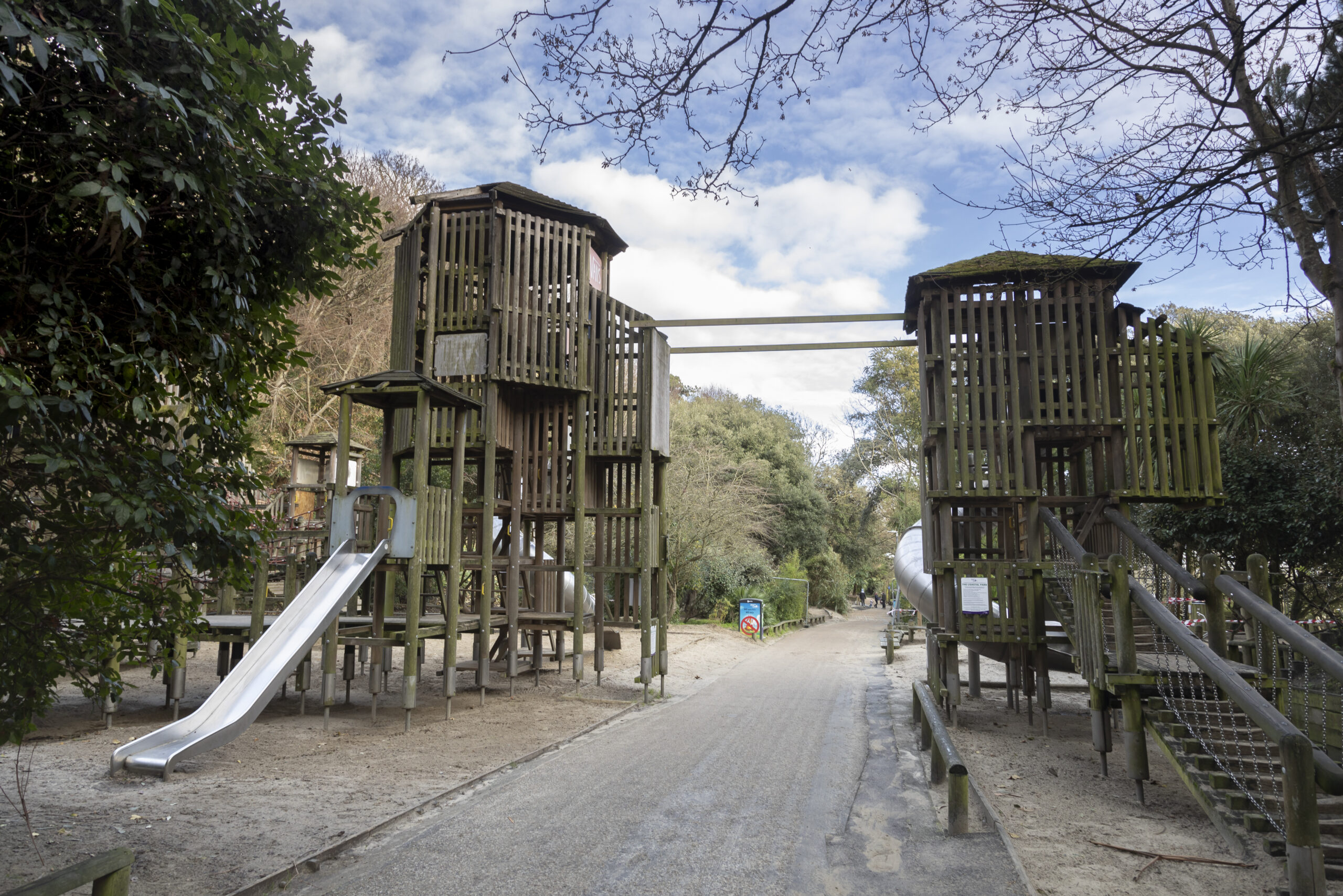 a wooden children's climbing frame with a slide