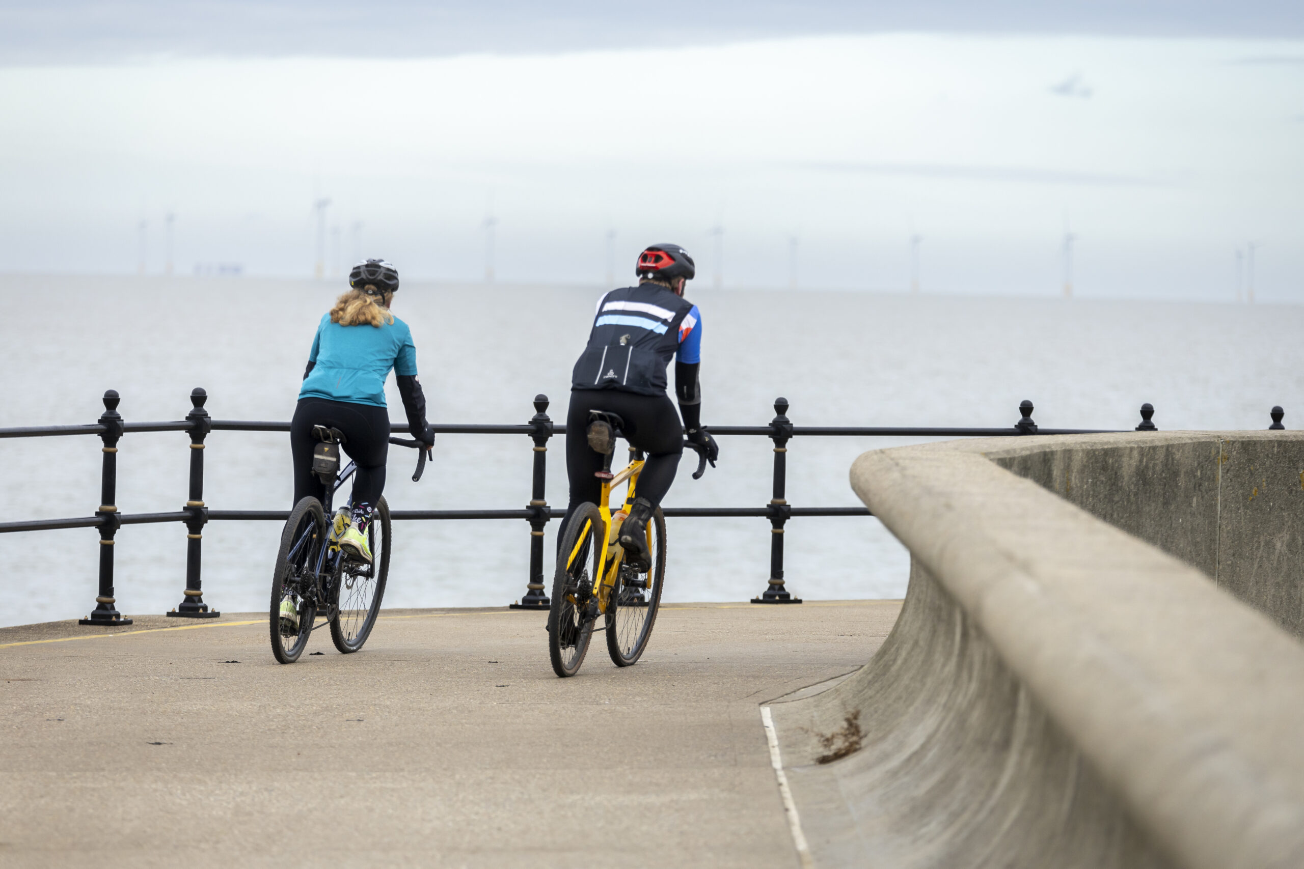 2 cyclists riding along a coast path