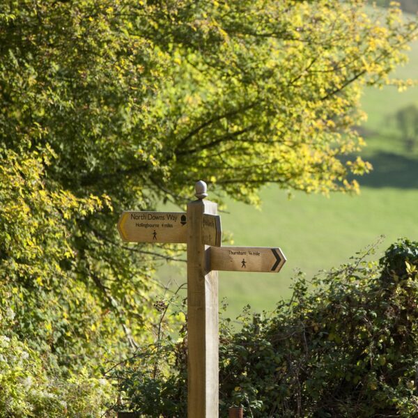 Signpost for the North Downs Way pointing left for Hollingbourne and right for Thurnham.
