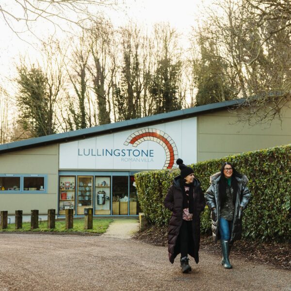 Two women walking in front of the entrance to Lullingstone Roman Villa,