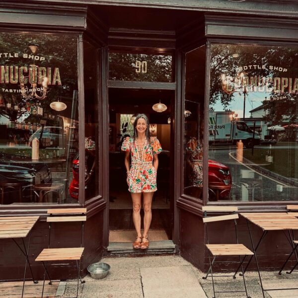 A woman standing in front of Cornucopia Bottle Shop entrance.