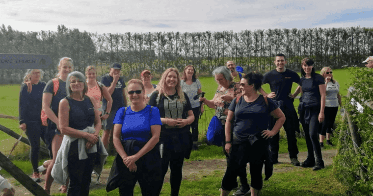 group of walkers standing in a field smiling at the camera