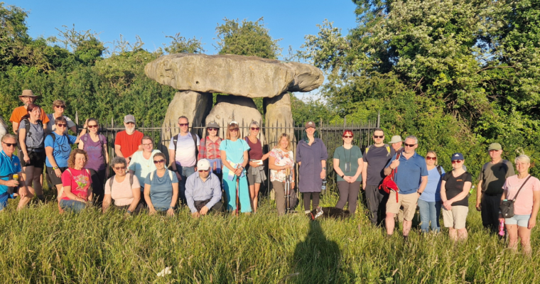Group of walkers in front of Kits Coty a prehistoric site