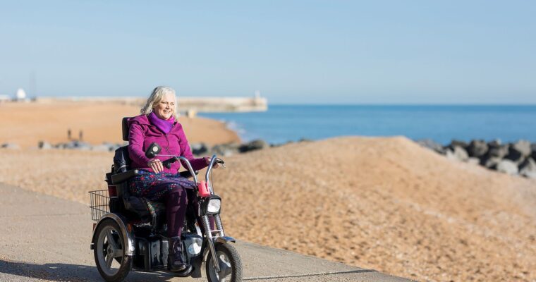 Wheeling along Folkestone beach in an electric wheelchair.