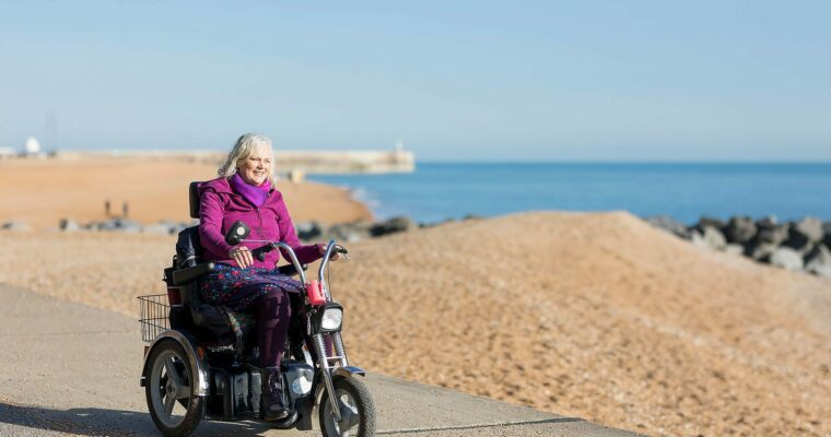 Wheeling along Folkestone beach in an electric wheelchair.