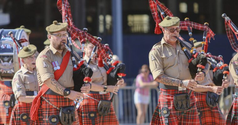 People in brown uniform playing Bagpipes