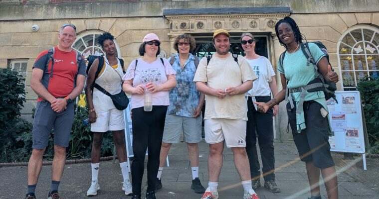 a group of walkers standing outside the library smiling at the camera